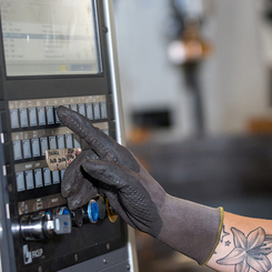 Weyland-Maschinenbediener an Produktionsmaschine – präzise Fertigung von Stahlträgern für Bau und Industrie